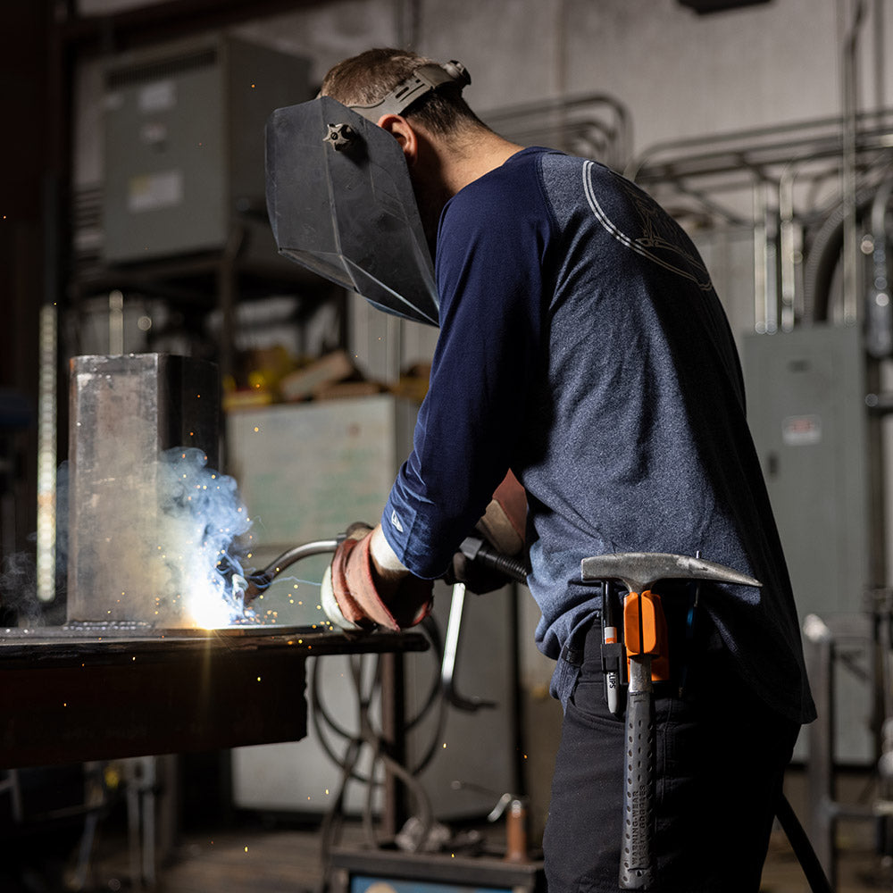 Worker using slag hammer holder to hold his hammer during work.