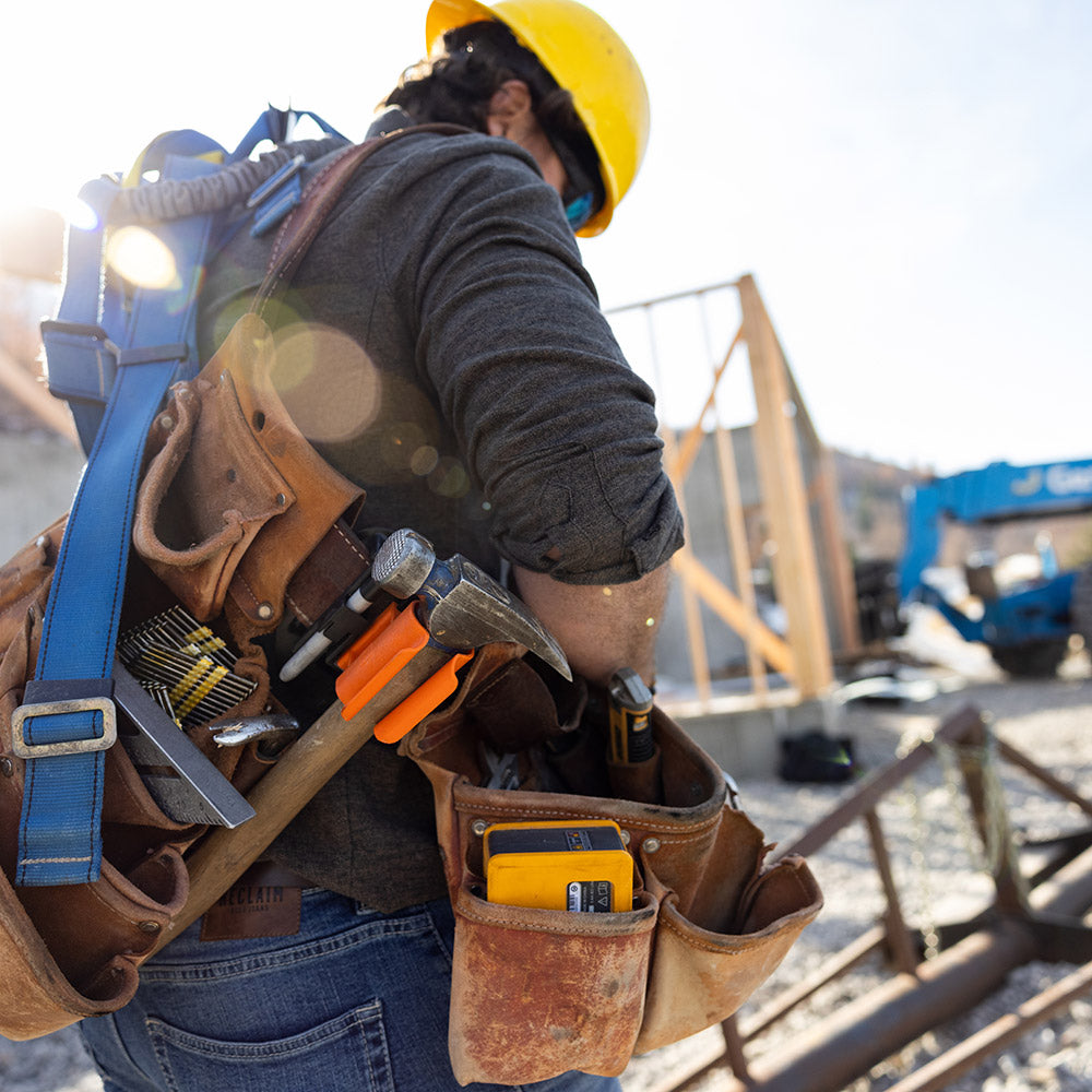 Framing hammer holder - Worker using framing hammer holder to hold his hammer during  construction work.